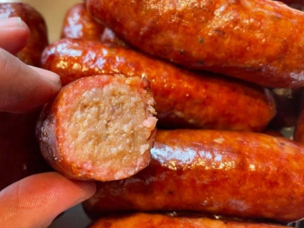 Delicious smoked sausage on a plate with a piece cut in half to show the smoke ring