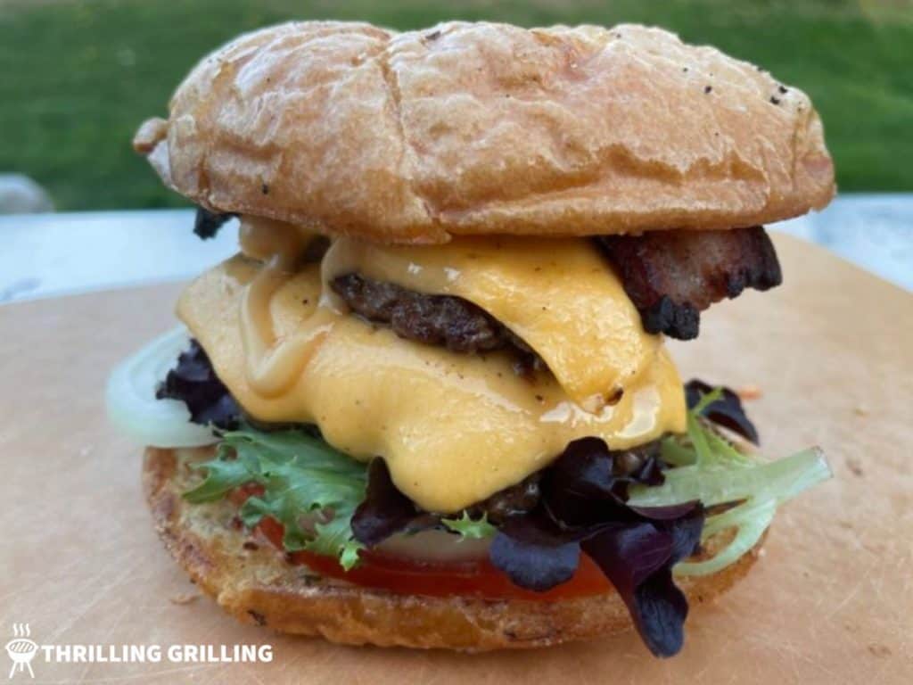 A double Blackstone Smash Burger on a bun with lettuce, tomato, onion, bacon, cheese, and a drizzle of homemade Smash Burger Sauce.