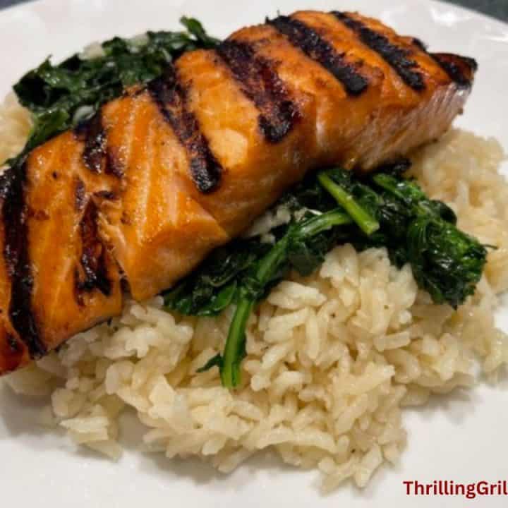 Grilled salmon on a bed of rice and broccoli rabe