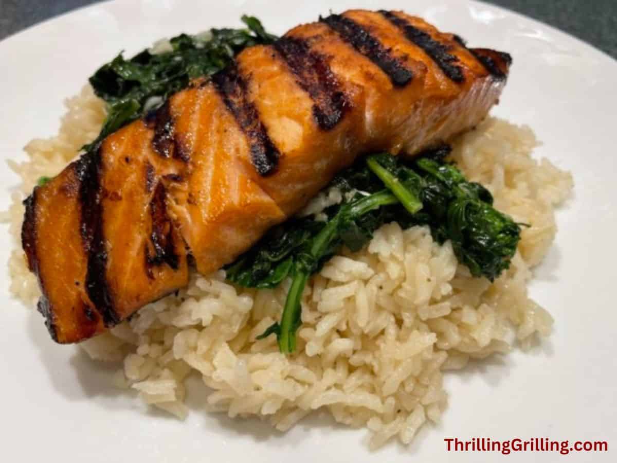Grilled salmon on a bed of rice and broccoli rabe