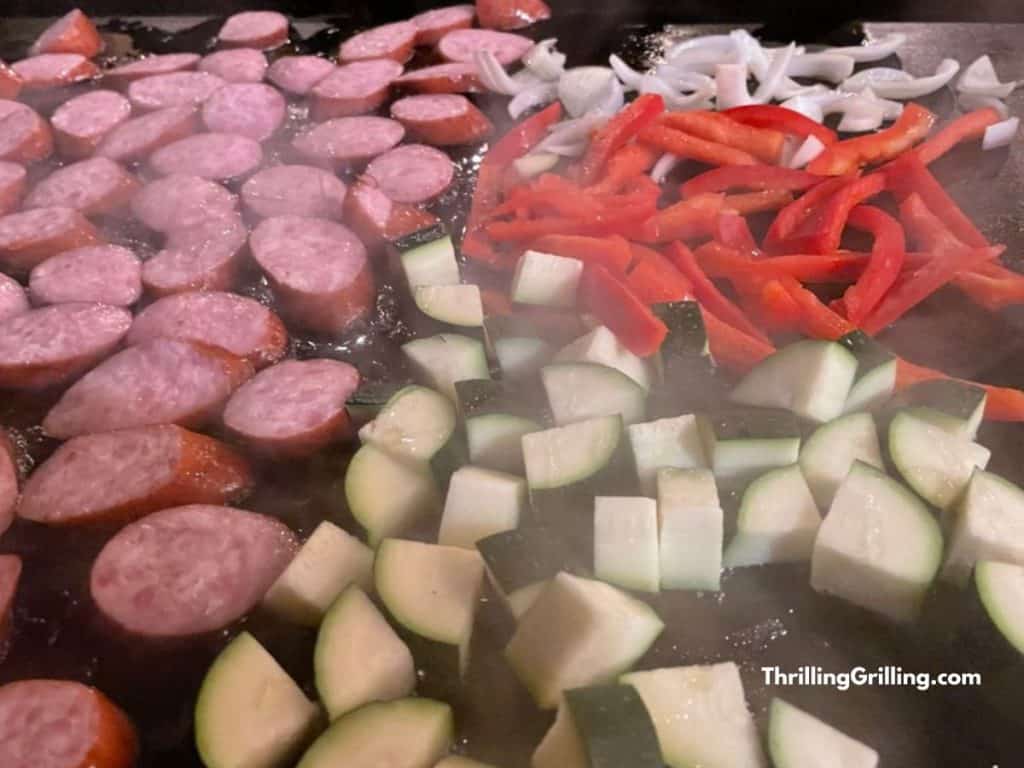Kielbasa, onion, zucchini, and red peppers cooking on the grill