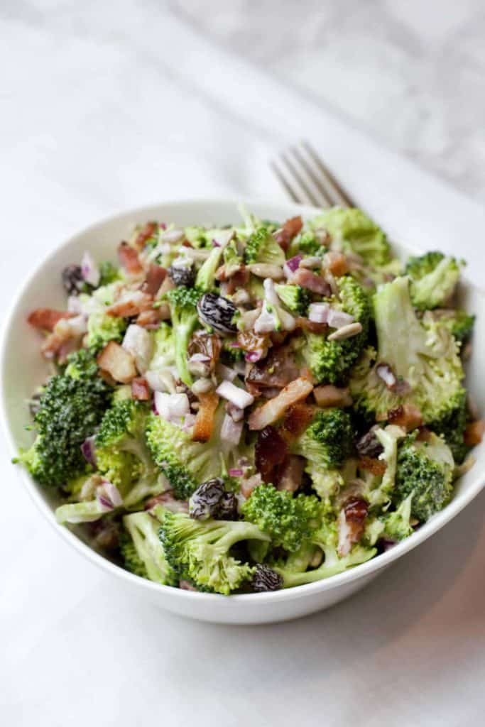 Closeup of broccoli crunch salad in a white bowl.