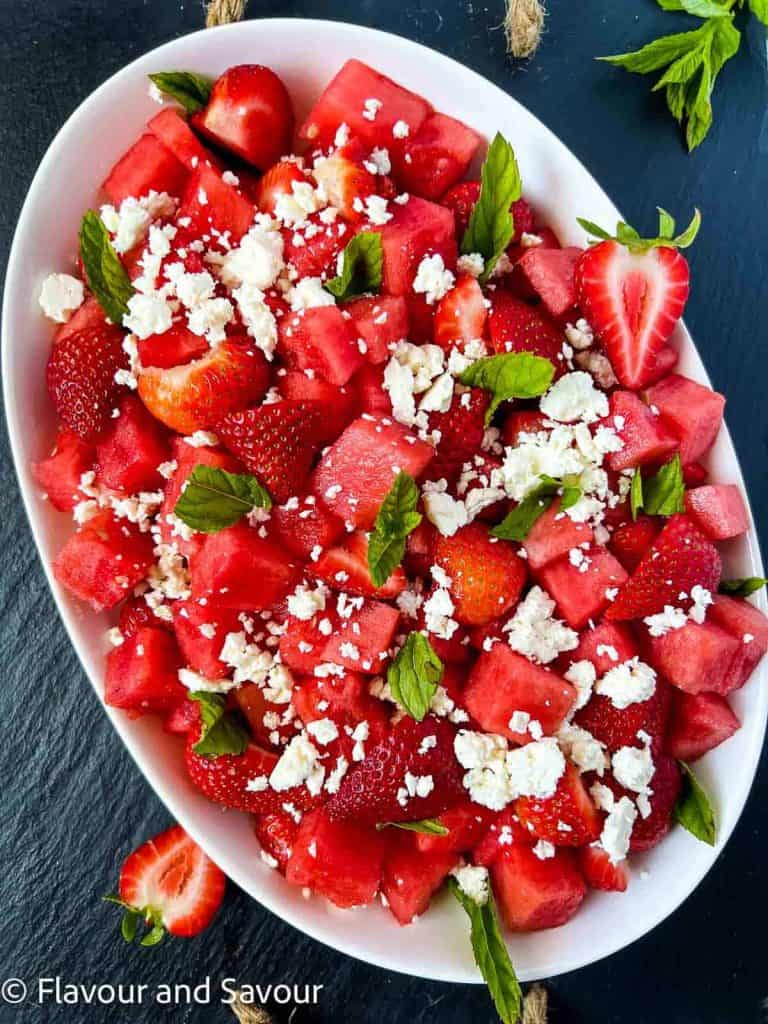 A white bowl full of strawberry and watermelon salad.