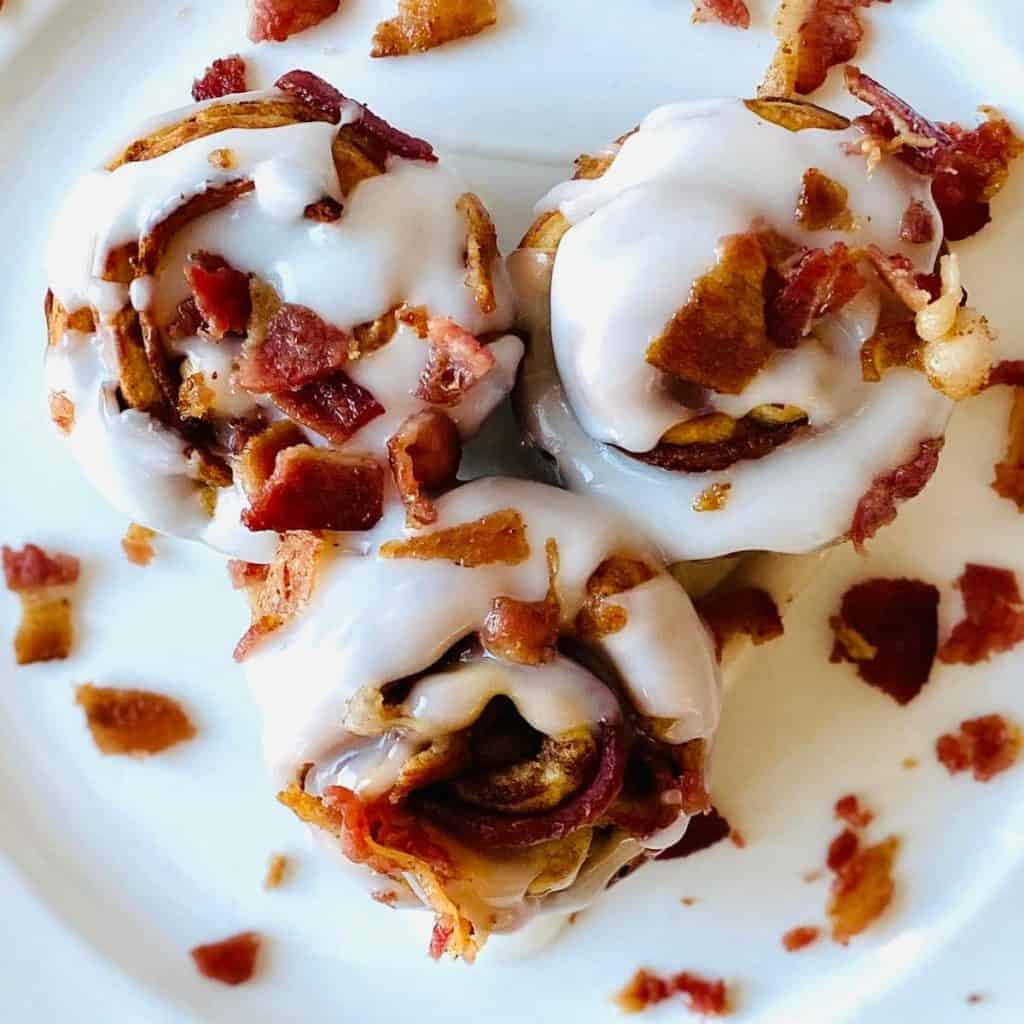 Cinnamon rolls with frosting and a sprinkle of bacon